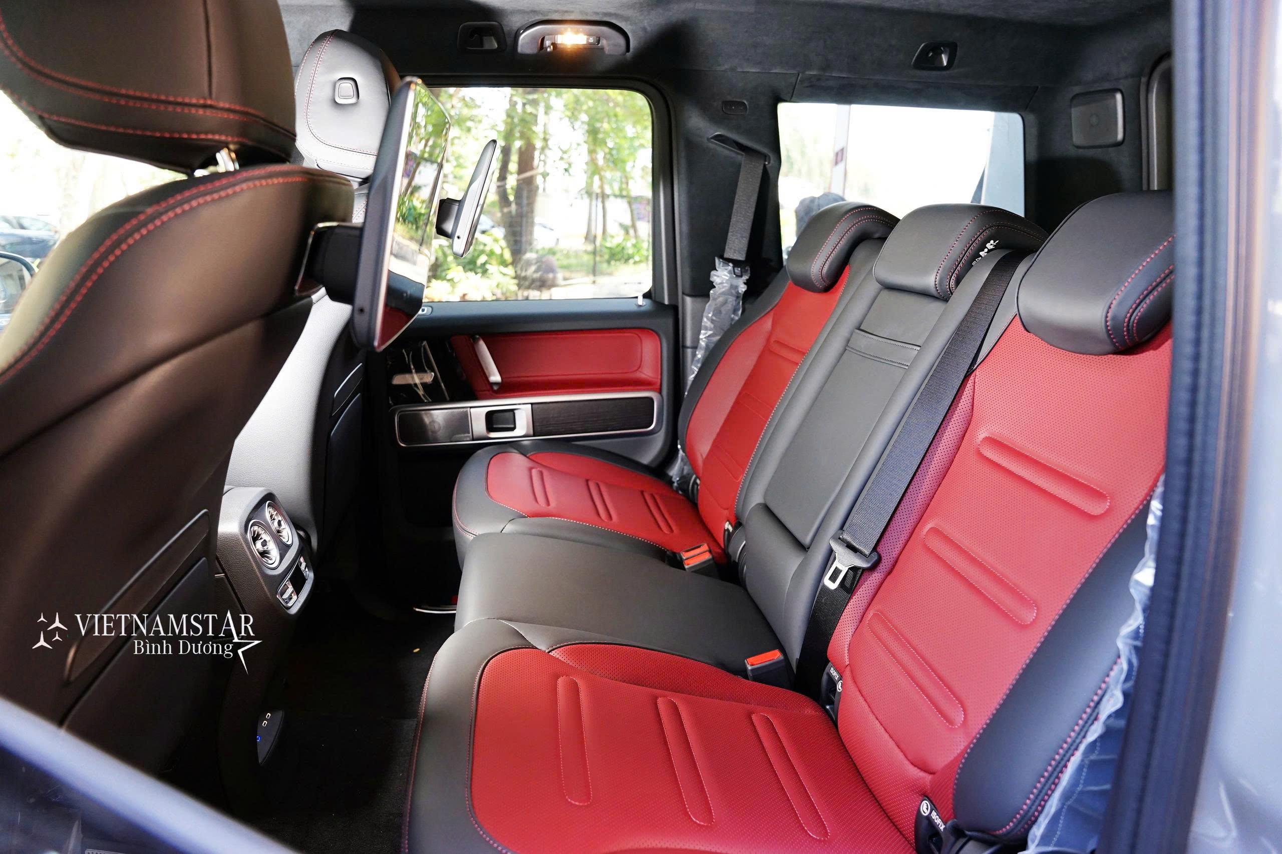 Các nút bấm mạ chrome tinh xảo trên nền da nội thất Đỏ Mercedes G580.