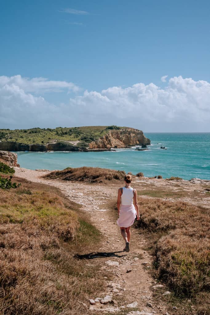 woman walking towards cliff edge in cabo rojo puerto rico